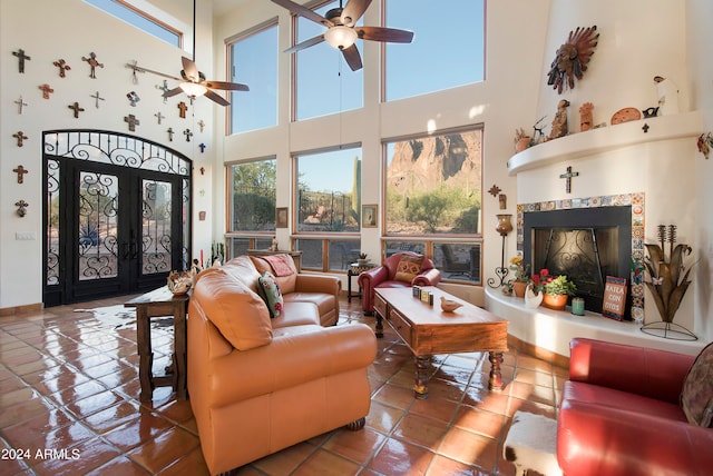 living room with a high ceiling, tile patterned flooring, and ceiling fan