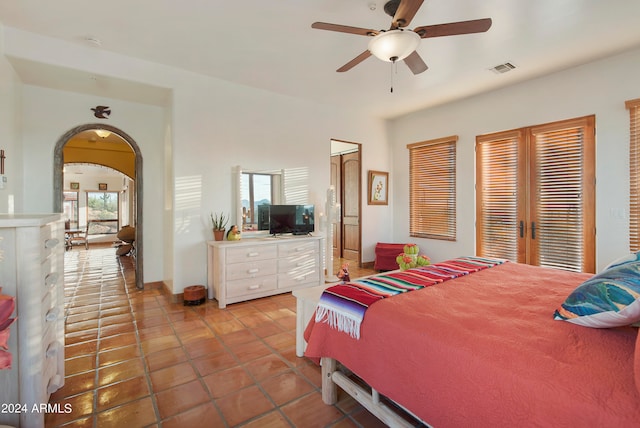 tiled bedroom with multiple windows and ceiling fan