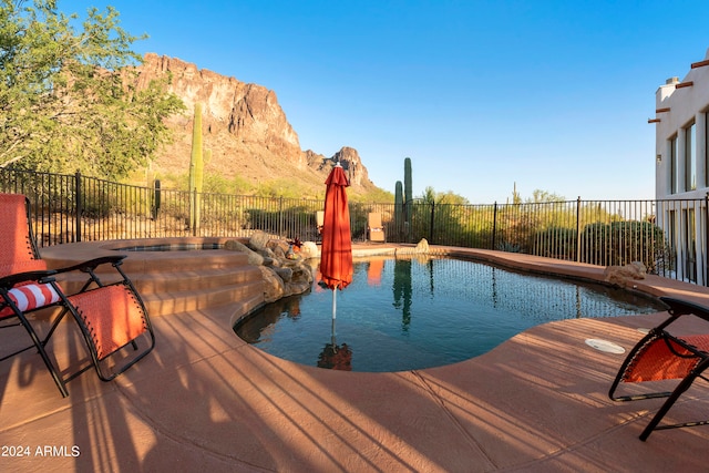 view of pool with a mountain view, an in ground hot tub, and a patio area