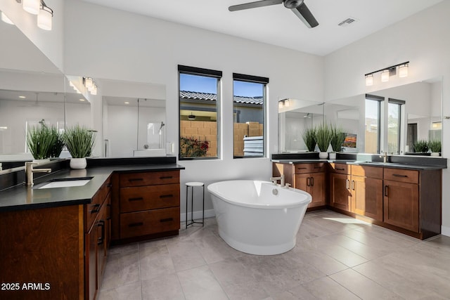 bathroom featuring ceiling fan, vanity, tile patterned floors, and a bathing tub