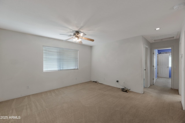 spare room with ceiling fan and light carpet