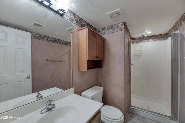 bathroom with toilet, a shower with shower door, a textured ceiling, vanity, and tile patterned flooring