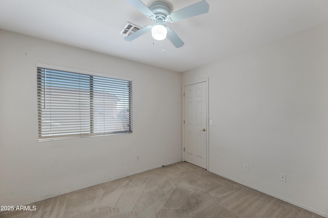 spare room featuring ceiling fan and light colored carpet