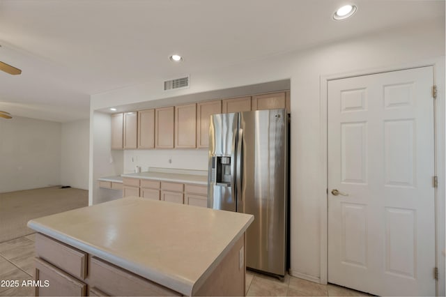 kitchen featuring light brown cabinetry, stainless steel fridge, a center island, light tile patterned floors, and ceiling fan