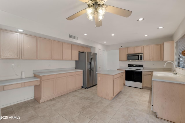 kitchen featuring sink, appliances with stainless steel finishes, a center island, light tile patterned flooring, and light brown cabinets