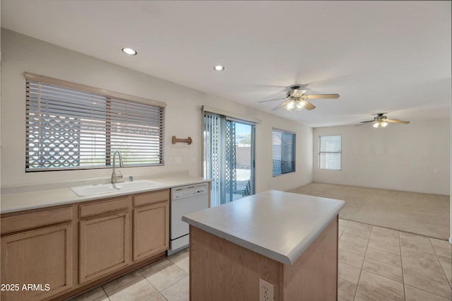 kitchen with sink, light brown cabinetry, dishwasher, a kitchen island, and light carpet