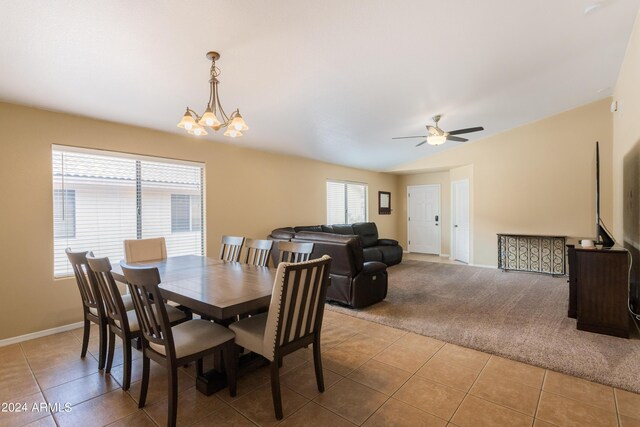 tiled dining space with ceiling fan with notable chandelier