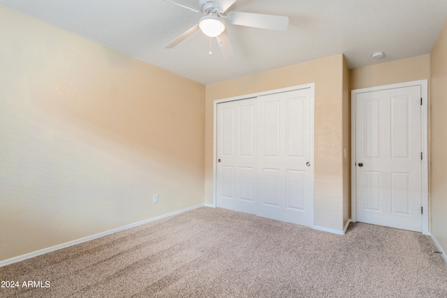 unfurnished bedroom featuring light carpet, a closet, and ceiling fan