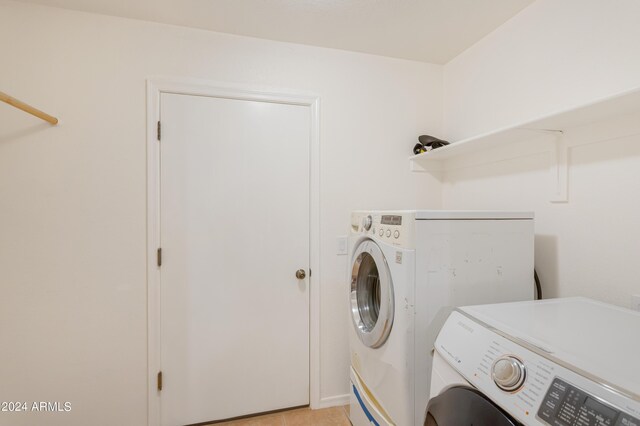 laundry room with light tile patterned flooring and washer and clothes dryer