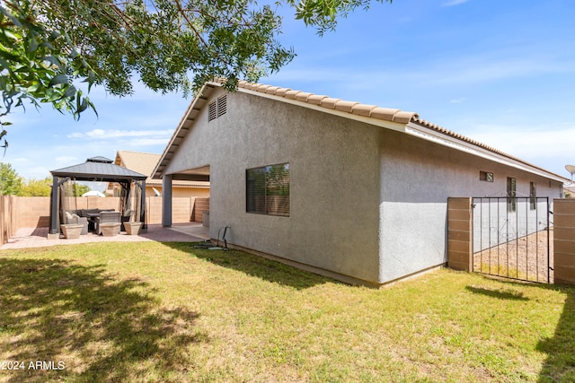 view of home's exterior featuring a lawn, a patio, and a gazebo