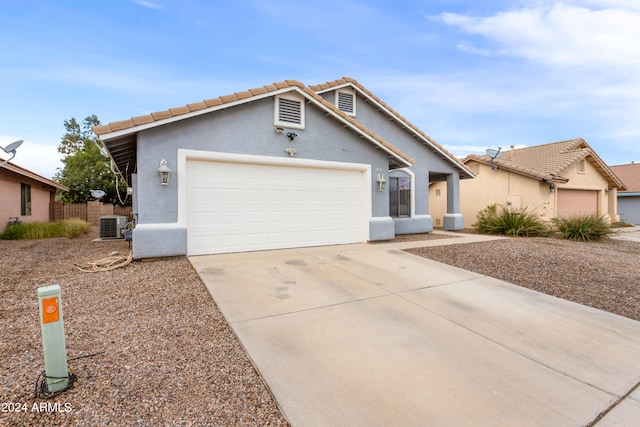 ranch-style house featuring a garage and central AC