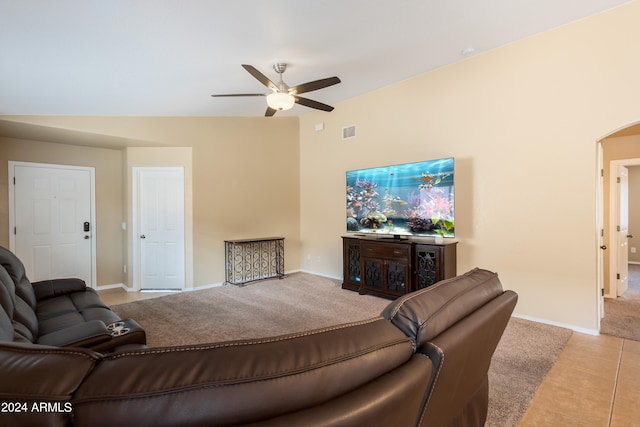 living room featuring ceiling fan, light tile patterned floors, and vaulted ceiling