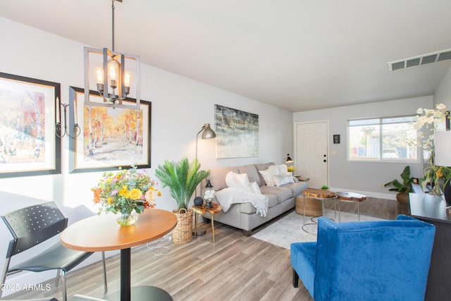 living room featuring wood-type flooring and a chandelier