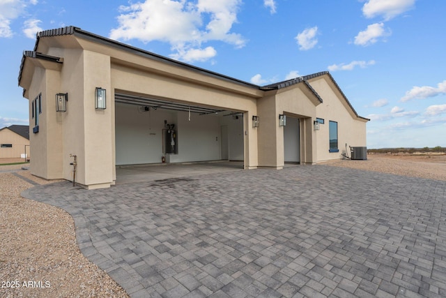 exterior space with a garage and central AC