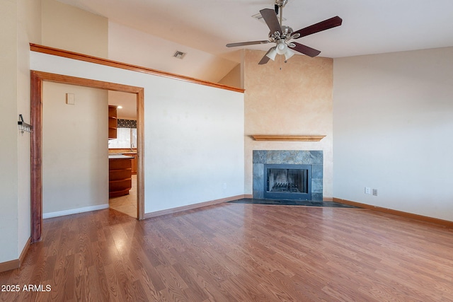 12613 N 51st Dr, Glendale, AZ 85304 - unfurnished living room featuring a ceiling fan, wood finished floors, a fireplace, vaulted ceiling, and baseboards
