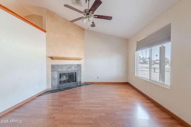 12613 N 51st Dr, Glendale, AZ 85304 - unfurnished living room featuring lofted ceiling, a ceiling fan, wood finished floors, a tiled fireplace, and baseboards