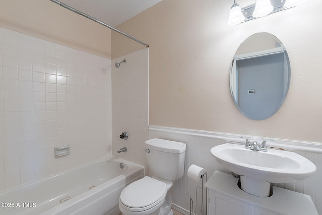 12613 N 51st Dr, Glendale, AZ 85304 - bathroom featuring toilet, shower / tub combination, a wainscoted wall, and a sink