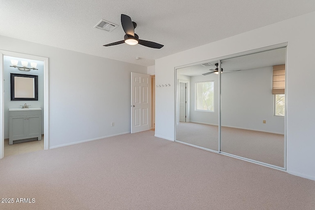 12613 N 51st Dr, Glendale, AZ 85304 - unfurnished bedroom with light colored carpet, ensuite bathroom, a closet, baseboards, and ceiling fan