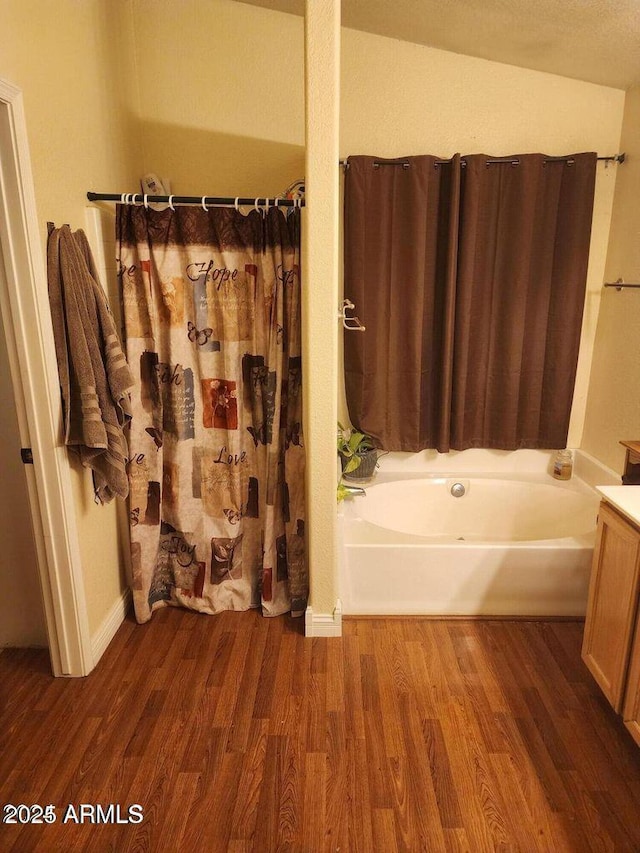 bathroom featuring a bathing tub, wood finished floors, and a shower with shower curtain