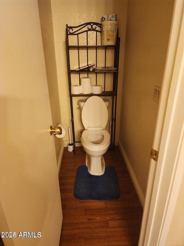 bathroom featuring toilet, baseboards, and wood finished floors