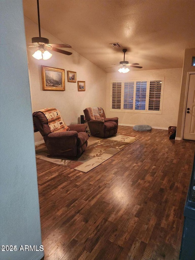 living room with a ceiling fan, visible vents, vaulted ceiling, and wood finished floors