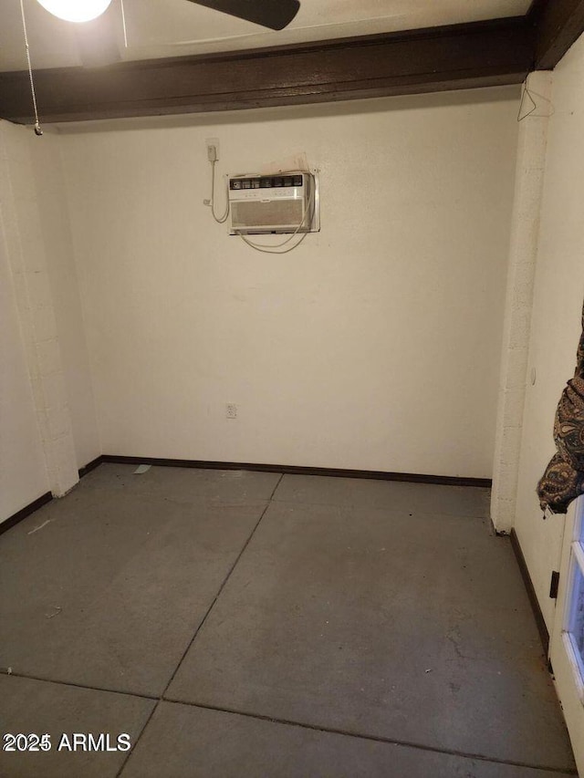 basement featuring a wall mounted air conditioner and baseboards