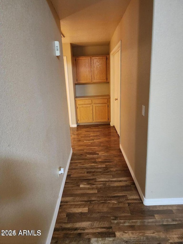 hall featuring baseboards and dark wood finished floors