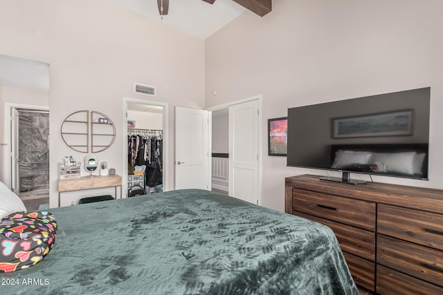 bedroom with beam ceiling, a spacious closet, ceiling fan, high vaulted ceiling, and a closet