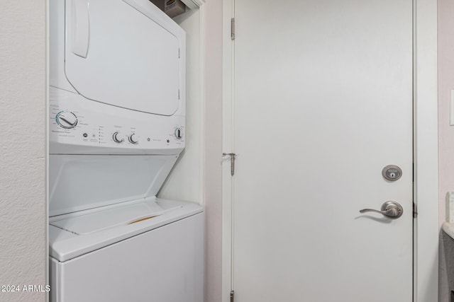 clothes washing area featuring stacked washer and dryer