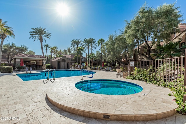 view of pool featuring a community hot tub and a patio area