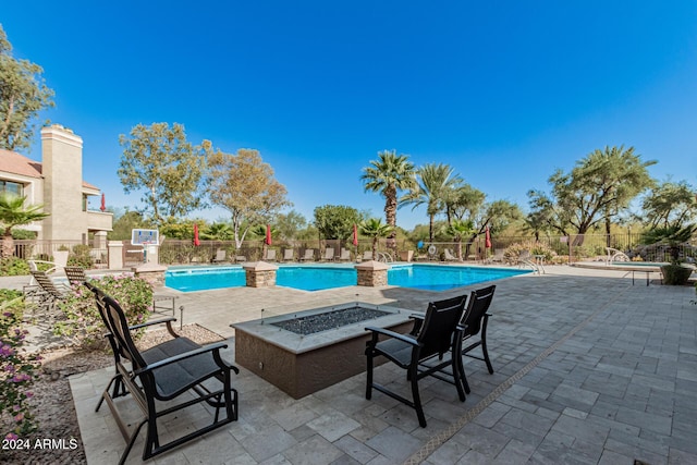 view of swimming pool with a patio and a fire pit