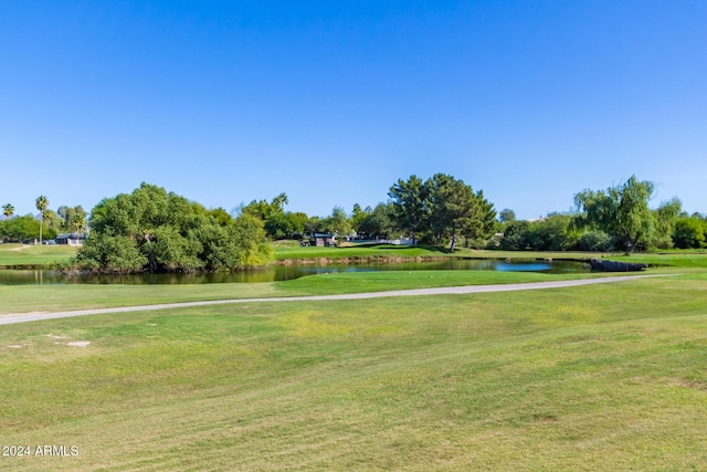 surrounding community with a lawn and a water view