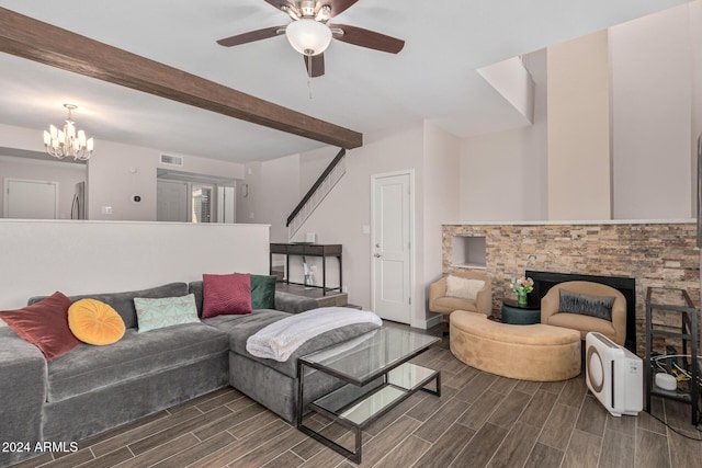 living room with a stone fireplace, beamed ceiling, dark wood-type flooring, and ceiling fan with notable chandelier