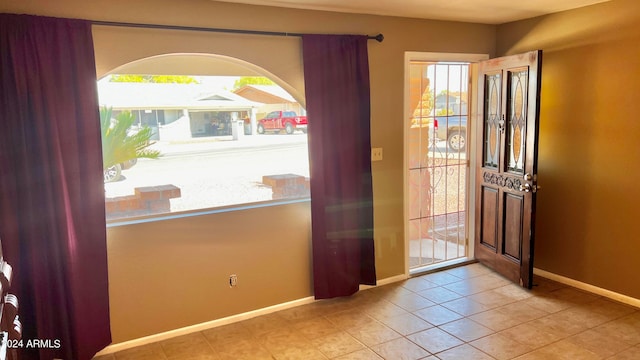 foyer featuring light tile patterned flooring and a healthy amount of sunlight