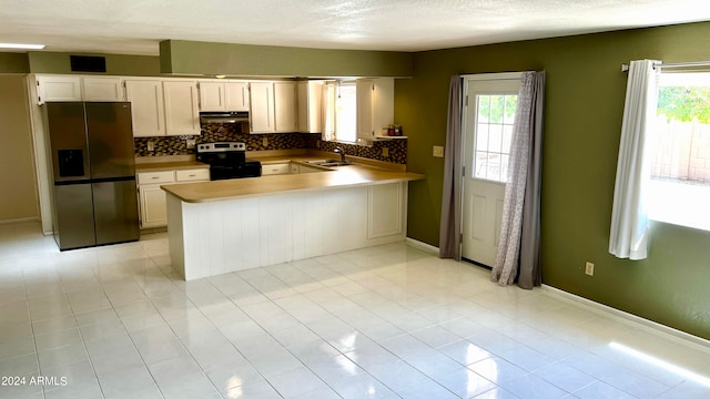 kitchen featuring white cabinetry, kitchen peninsula, appliances with stainless steel finishes, and sink