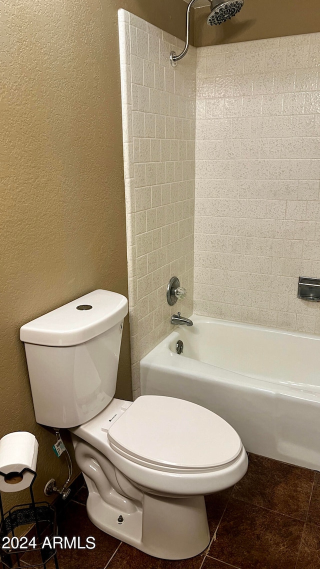 bathroom featuring tile patterned floors, tiled shower / bath, and toilet