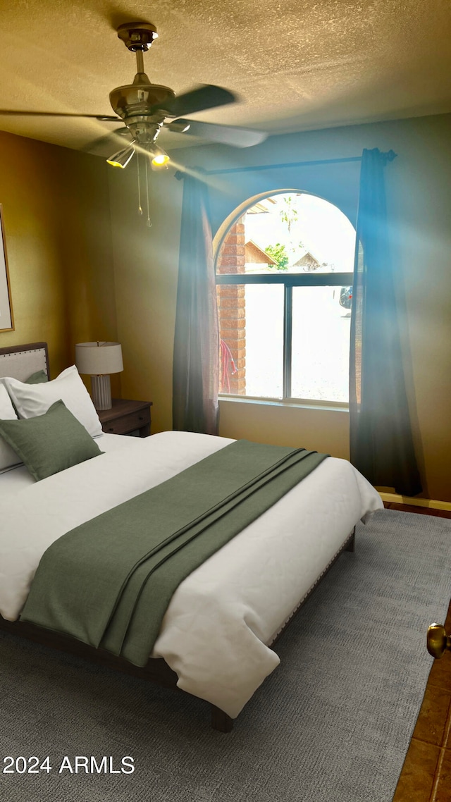 bedroom featuring a textured ceiling and ceiling fan