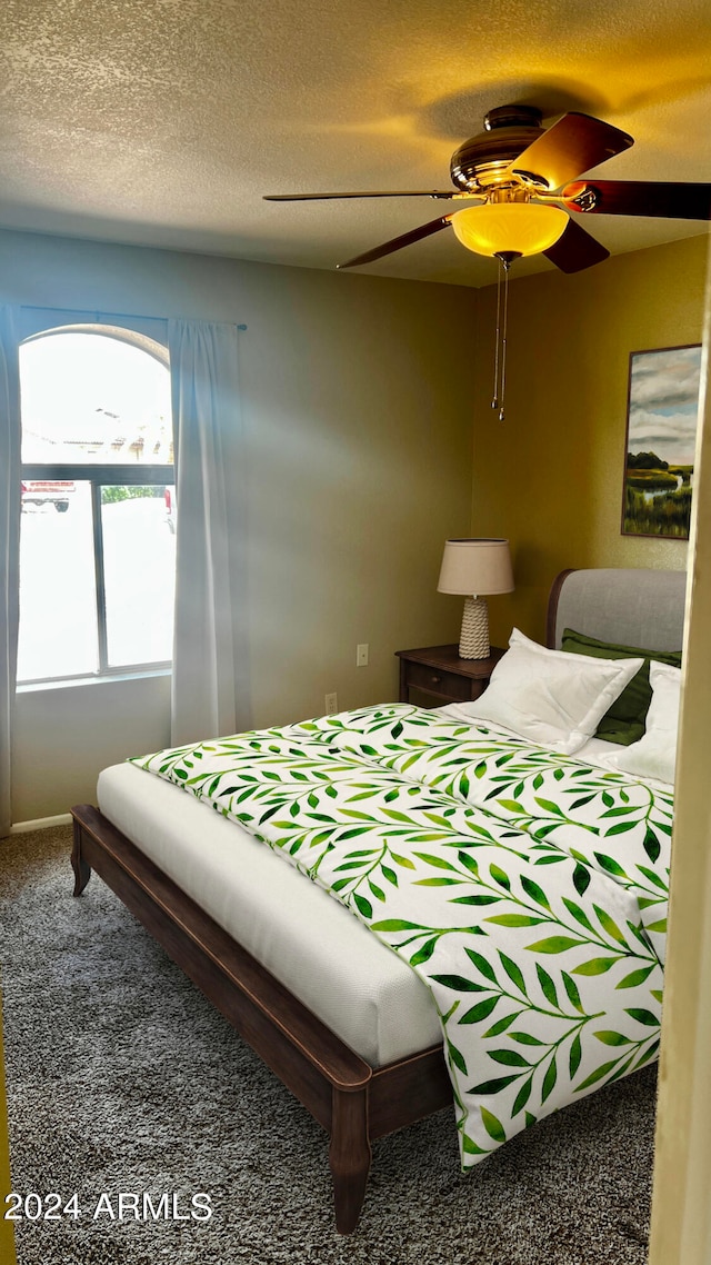 bedroom featuring a textured ceiling, carpet, and ceiling fan