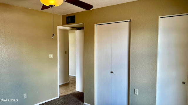 unfurnished bedroom featuring ceiling fan, a textured ceiling, and tile patterned flooring