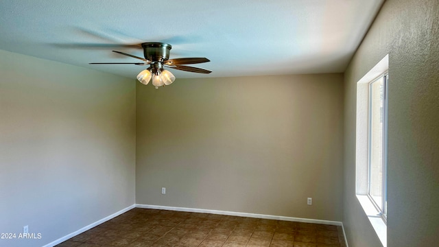 empty room featuring ceiling fan and plenty of natural light