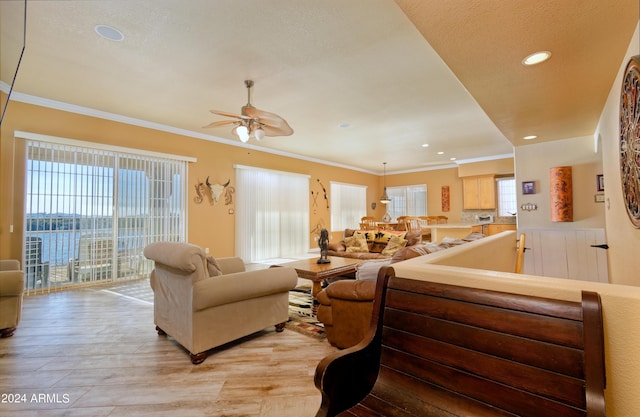 living room with ornamental molding, light wood-type flooring, and plenty of natural light