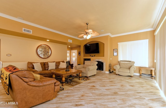 living area with ornamental molding, visible vents, a fireplace, and ceiling fan