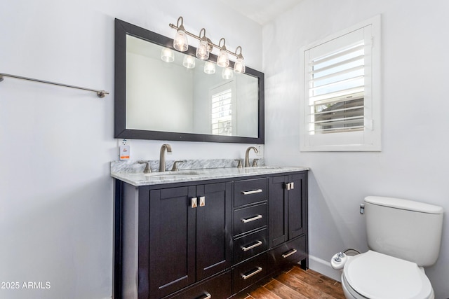 1334 W Sells Dr, Phoenix, AZ 85013 - bathroom with wood finished floors, toilet, baseboards, and double vanity