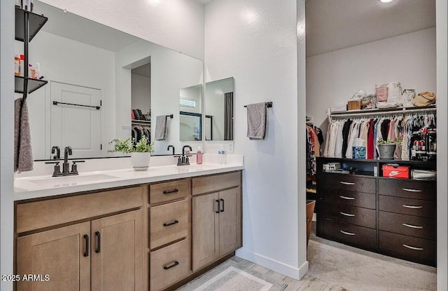16955 W Butler Ave, Waddell, AZ 85355 - bathroom featuring a walk in closet and double vanity