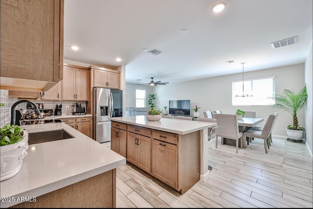 16955 W Butler Ave, Waddell, AZ 85355 - kitchen featuring stainless steel fridge with ice dispenser, a sink, light countertops, a center island, and recessed lighting