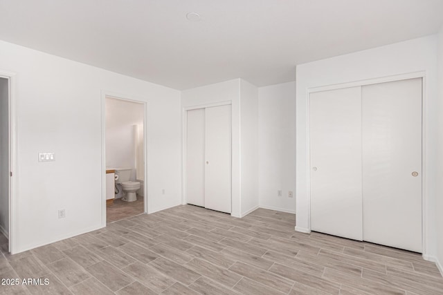 12132 W Dahlia Dr, El Mirage, AZ 85335 - unfurnished bedroom with multiple closets, light wood finished floors, ensuite bathroom, and baseboards