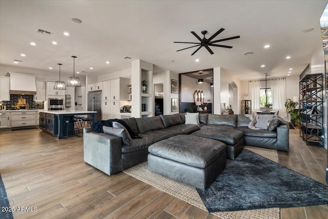 20715 E Watford Dr, Queen Creek, AZ 85142 - living room featuring wood finished floors, arched walkways, a ceiling fan, and recessed lighting