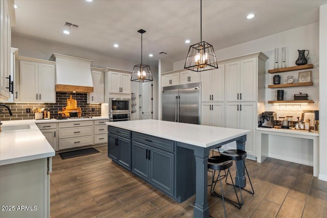 20715 E Watford Dr, Queen Creek, AZ 85142 - kitchen with built in appliances, custom exhaust hood, a center island, a sink, and light countertops