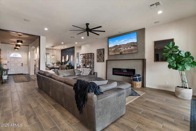 20715 E Watford Dr, Queen Creek, AZ 85142 - living room featuring wood finished floors, ceiling fan, recessed lighting, baseboards, and arched walkways