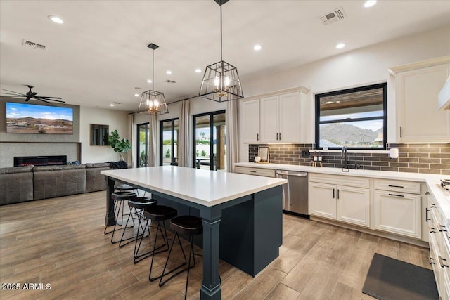 20715 E Watford Dr, Queen Creek, AZ 85142 - kitchen featuring stainless steel dishwasher, a kitchen island, a breakfast bar, tasteful backsplash, and recessed lighting